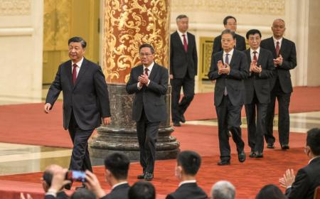 Le président chinois Xi Jinping (gauche) marche devant Li Qiang, Li Xi, Zhao Leji, Ding Xuexiang,