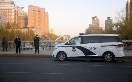 Des policiers surveillent une rue près de la rivière Liangma, site de récentes manifestations contre